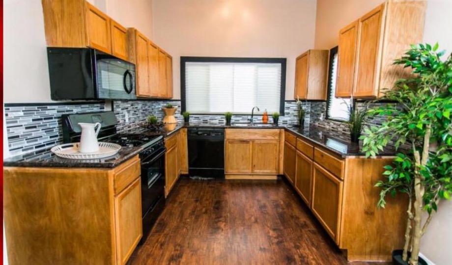 Updated kitchen with wood cabinetry and dark countertops